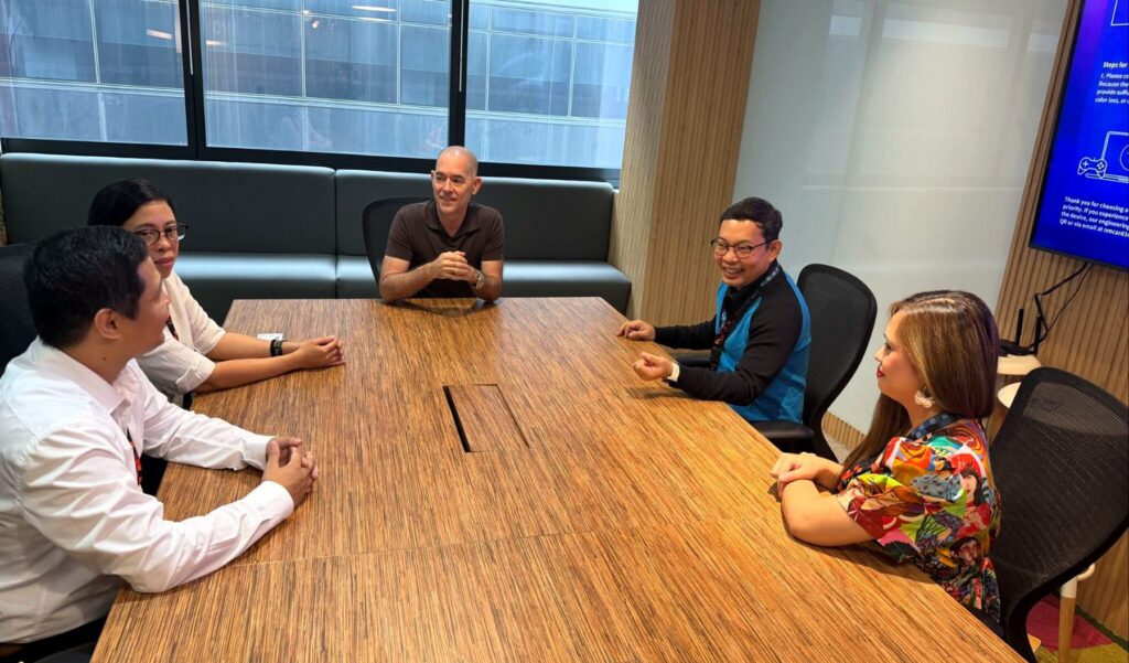 Andy Schachtel at the head of a conference table with four Sourcefit colleagues