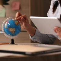 unrecognizable-businesswoman-using-digital-tablet-while-examining-globe-planning-her-vacation unrecognizable-businesswoman-using-digital-tablet-while-examining-globe-planning-her-vacation